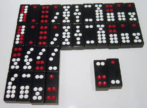 Photo of a set of Chinese dominoes The top double row of tiles lists the eleven matching pairs in descending value from left to right for Pai Gow Poker Game