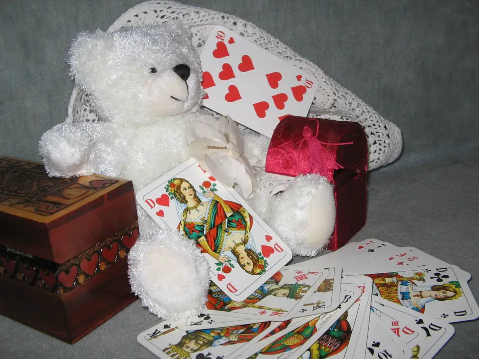 teddy bear besides playing cards